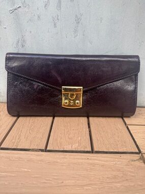 Zina Eva clutch wristlet dark aubergine leather with a gold-tone lock closure